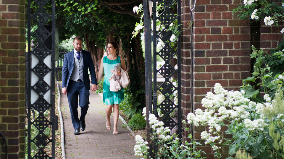 Wedding couple walking through garden gate